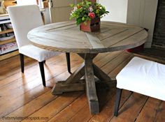 a wooden table sitting on top of a hard wood floor next to a white chair