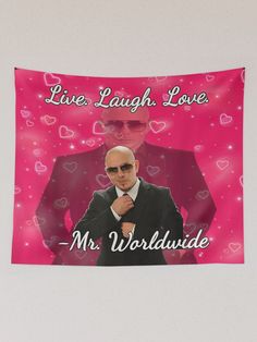 a man in a suit and tie with hearts on the wall behind him that says, live laugh love mr world wide