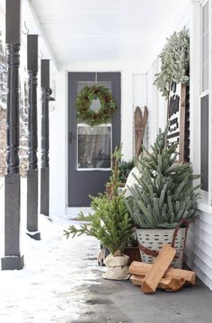 the front porch is decorated for christmas with evergreens and pine cones