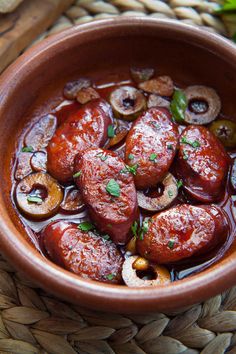 a brown bowl filled with sausage and mushrooms