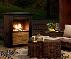 a patio with wicker furniture and an outdoor fire place in the background at night