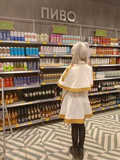 a woman standing in front of a store filled with drinks