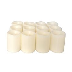 twelve white candles are lined up against a white background