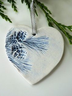 a ceramic ornament shaped like a heart with blue and white designs on it