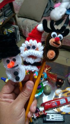 three crocheted snowman and reindeer pencil toppers in the shape of animals