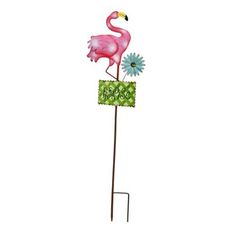 a pink flamingo standing on top of a sign