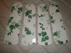 four white and green plates sitting on top of a bed