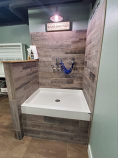 a bathtub in a bathroom with wood paneling on the walls and tile floor