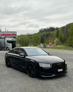 a black car parked in front of a truck