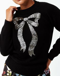 This sale item is final sale. No returns or exchanges will be accepted. Crew neck sweater with handmade beaded bow embellishment Raglan style shoulder seams Ribbed collar, cuffs, and hem 100% Cotton Yarn Spot clean, hand wash, or dry clean only Model height: 5’9” | Knit length: 22” Hand Embroidery Sweater, Appa Embroidery, Split Sweater, Bow Embroidery, Beaded Bow, Holiday Knits, Bow Sweater, Embroidery Sweater, Embellished Sweaters