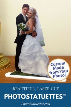 a wedding cake topper with a bride and groom on it, in front of a gold trophy