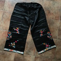 "Vintage black satin pajama pants with embroidered orange, pink, gold, green cherry blossom branches and peonies. LARGE-- SHORT, CROPPED LENGTH CONDITION: excellent- appear unworn VINTAGE: circa 1920 WAIST: elastic 29\" to 40\"\" HIPS: 48\"  LENGTH: 32\", outer seam, 22\" inseam LINING: none LABEL: none MATERIAL: non-stretch satin POCKETS: no NOTES: Wearable, but CAREFULLY.  This item is sent via the US postal service with insurance.  International shipping is $27.  NecromanceNOLA is not responsible for any import fees or delays due to customs." Traditional Silk Pants For Summer, Embroidered Bottoms For Spring Loungewear, Vintage Loungewear Pants For Spring, Vintage Spring Loungewear Pants, Spring Embroidered Bottoms For Loungewear, Spring Vintage Loungewear Pants, Black Bottoms For Pajama Party In Spring, Black Pants For Summer Pajama Party, Casual Lounge Pants With Floral Embroidery