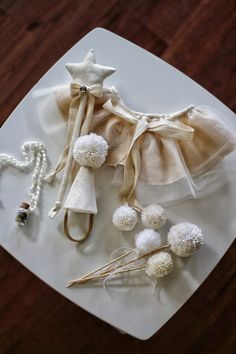 a white plate topped with pom poms next to a pair of scissors and other items