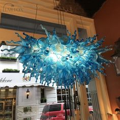 a blue chandelier hanging from the ceiling in front of a storefront window