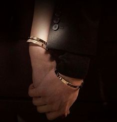 two people holding hands in the dark with their arms wrapped around each other's wrists