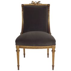 an antique chair with gold trimmings and black leather upholstered backrest