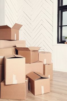 several boxes stacked on top of each other in front of a wall with a window