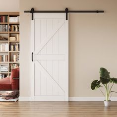 a living room with a book shelf and sliding barn door in the center, next to a red chair