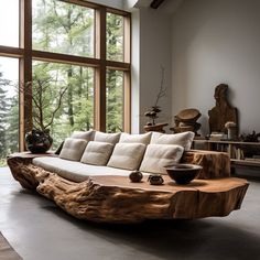 a living room filled with lots of furniture next to large windows and wooden pieces on the floor