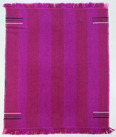 a pink and purple striped rug with fringes on the bottom, against a white background