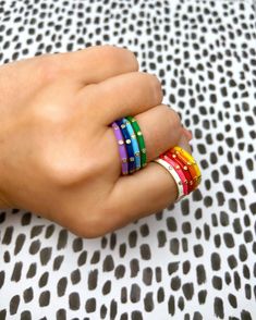 I'm sexy, I'm cute, I'm popular to boot." Embrace your inner cheerleader and show your colors with pride with our stack of ten enamel rings. Set of 10 stack rings in every color. White, Pink, Red, Orange, Yellow, Green, Light Blue, Dark Blue, Light Purple, and Black. Details: Our enamel stack ring features 10 zircon stones set in sterling silver plated with 18k yellow gold. 2mm wide. Enameling Jewelry, Enamel Rings, Stack Rings, Preppy Jewelry, Dainty Band, Pop Color, Stack Ring, Stacking Ring Set, Enamel Ring