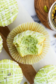 cupcakes with green frosting and nuts in the background