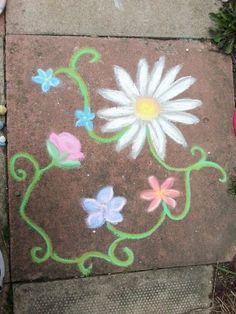 the sidewalk is decorated with flowers and vines painted on it's side by someone