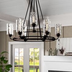 a chandelier hanging from the ceiling in a room with french doors and windows