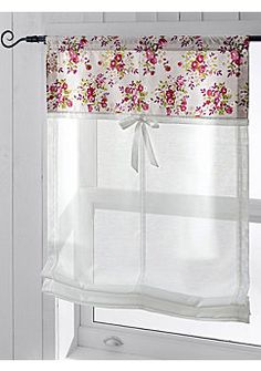 an open window with white curtains and pink flowers on the valance, along with a bow tie