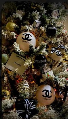 a christmas tree decorated with ornaments and chanel stickers on it's branches