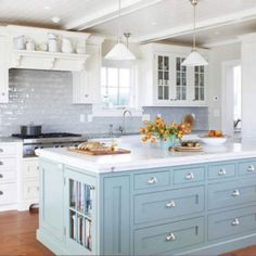 a kitchen with white cabinets and green island