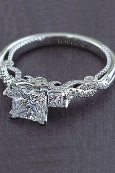 a princess cut diamond engagement ring with filigrees