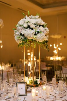 an elegant centerpiece with white flowers and greenery