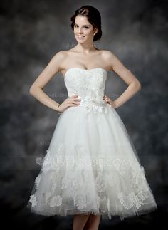 a woman in a short white dress posing for a photo with her hands on her hips