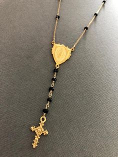 "This is a gorgeous rosary necklace with Onyx gemstone on Goldfilled chain and clasp. Necklace is 16\" with 2\" extender with 18k gold filled Miraculous Mary medallion hangs at center with 2\" drop. This special Necklace will arrive to you or someone special in a gift box." Elegant Adjustable Crucifix Jewelry, Spiritual Style Lariat Necklace As Gift, Adjustable Crucifix Jewelry For Jewelry Making, Adjustable Cross Lariat Necklace As Gift, Gold Single Strand Lariat Necklace As Gift, Adjustable Crucifix Necklace With Adjustable Chain, Adjustable Crucifix Necklace For Gift, Gold Single Strand Lariat Necklace Gift, Spiritual Lariat Necklace With Adjustable Chain