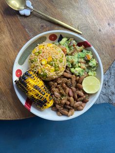 a white plate topped with corn, rice and beans