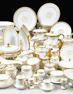 a pile of white and gold china sitting next to each other