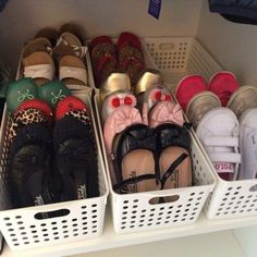 there are many pairs of baby shoes in the bins on the shelf next to each other