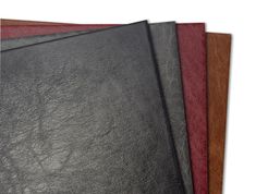 three different colored leathers are stacked on top of each other, with one being black and the other is red