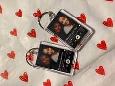 two personalized keychains with red hearts on white paper and one has a couple's photo attached to it