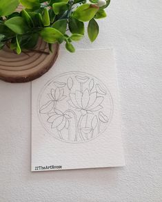 a potted plant sitting on top of a table next to a piece of paper