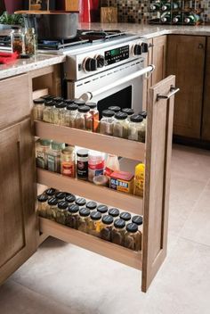 an open spice rack in the middle of a kitchen