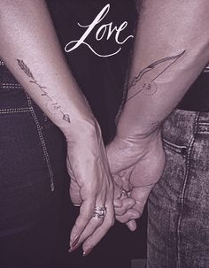 two people holding hands with the words love written on their arm and one person's hand behind them