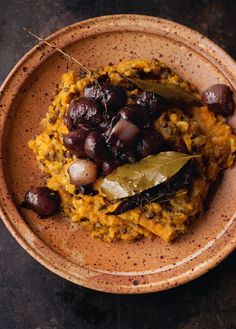 a bowl filled with rice and olives on top of a table