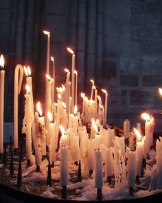 many white candles are lit in the snow