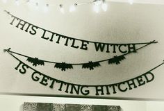 this little witch is getting hitched sign hanging on the wall in front of a fireplace