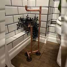 a bathroom with white tiles and copper pipes