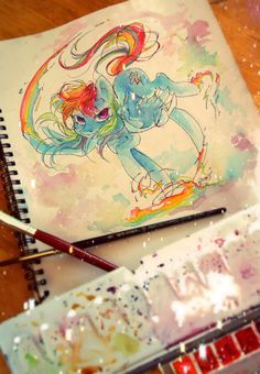 an artist's notebook with watercolors and paint