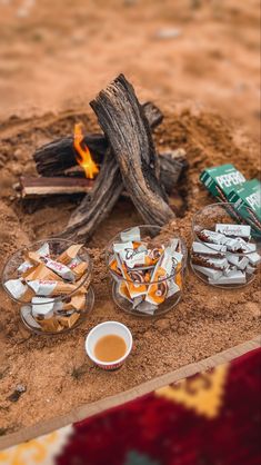 a campfire with snacks and tea on the ground