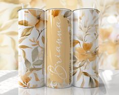 three metal cans with flowers painted on them